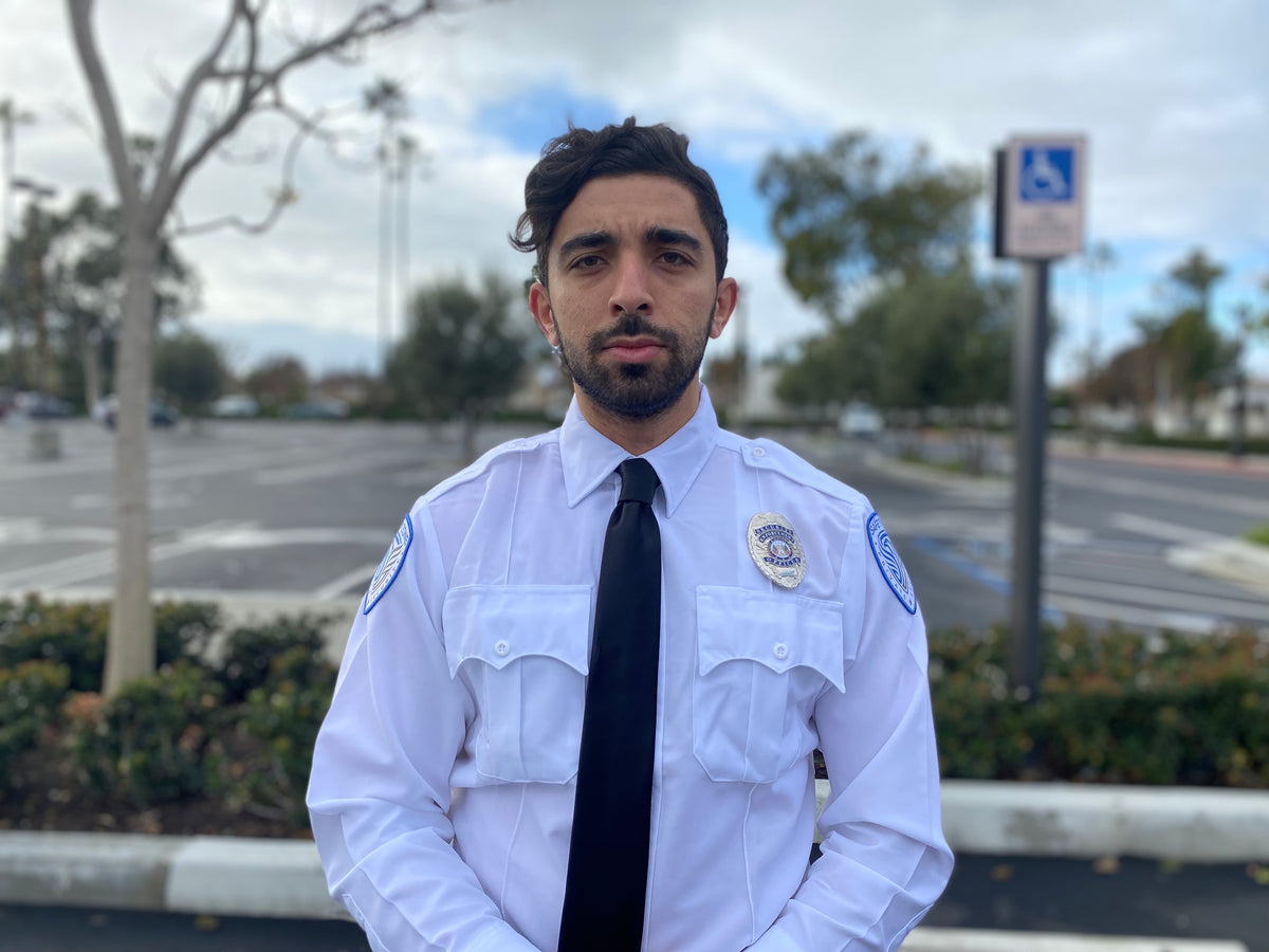 safety zone security officer in uniform with hands placed on stomach, providing security guard services in california parking lot